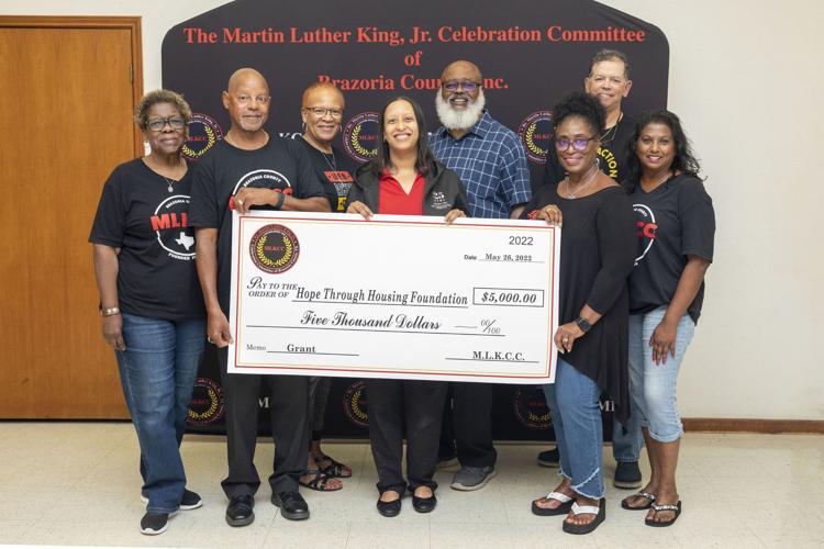 Hope through Housing team members are presented a ceremonial check from Martin Luther King Jr. Celebration Committee